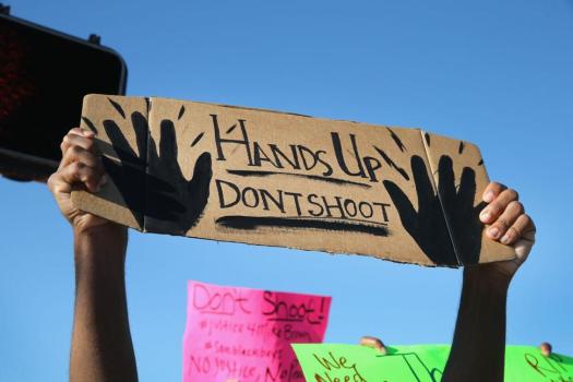 Protesters holding up the universal sign for surrender, which is what witnesses said Brown did before being fatally wounded by Officer Darren Wilson. (Google Images)