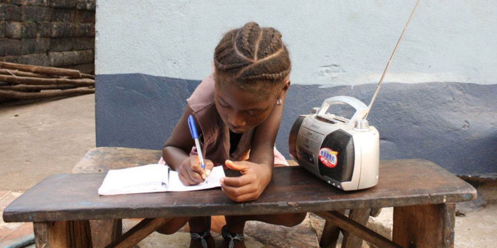 A young girl listens to a radio broadcast of educational lessons in Sierra Leone. (Photo: Google Images)